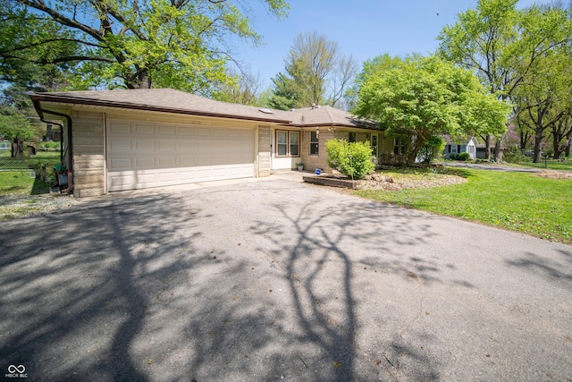4710 E 56th St, Indianapolis, IN 46220 - ranch-style house featuring a front yard, aphalt driveway, and an attached garage