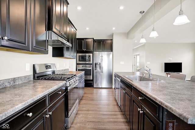 13567 Moorcroft Dr, Fishers, IN 46037 - kitchen featuring appliances with stainless steel finishes, under cabinet range hood, a sink, light wood-style floors, and decorative light fixtures