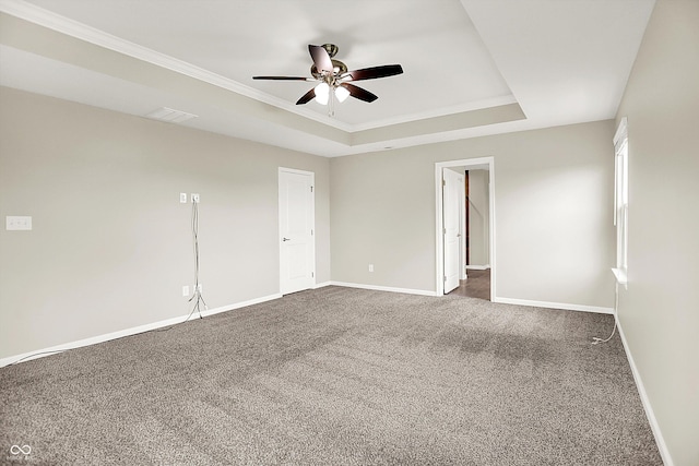 13567 Moorcroft Dr, Fishers, IN 46037 - spare room featuring dark colored carpet, ceiling fan, a raised ceiling, baseboards, and ornamental molding