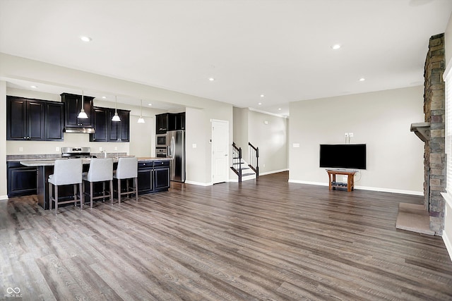 13567 Moorcroft Dr, Fishers, IN 46037 - kitchen featuring stainless steel appliances, open floor plan, under cabinet range hood, light countertops, and dark wood finished floors