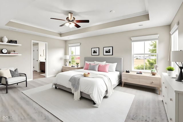 13567 Moorcroft Dr, Fishers, IN 46037 - bedroom featuring a tray ceiling, light wood-style flooring, crown molding, connected bathroom, and ceiling fan
