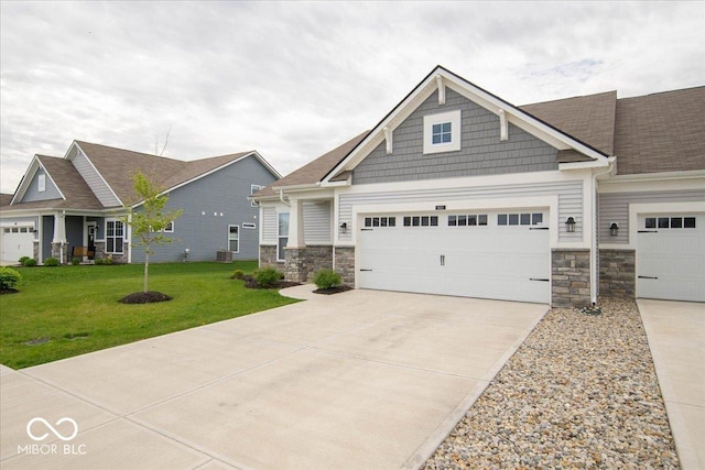 9455 Orchard Cove Dr, Indianapolis, IN 46239 - craftsman house featuring an attached garage, stone siding, a front yard, and concrete driveway