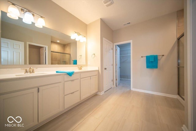 9455 Orchard Cove Dr, Indianapolis, IN 46239 - full bathroom featuring double vanity, a walk in closet, visible vents, a stall shower, and a sink