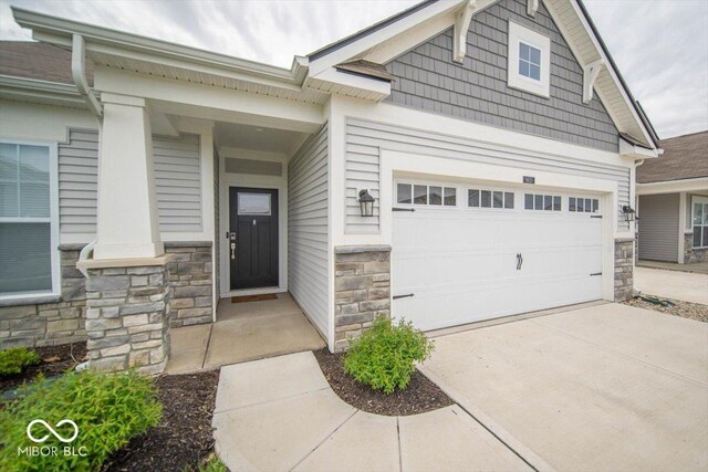 9455 Orchard Cove Dr, Indianapolis, IN 46239 - property entrance with driveway, stone siding, and a garage