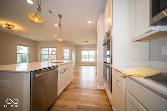 9455 Orchard Cove Dr, Indianapolis, IN 46239 - kitchen with light wood-type flooring, a sink, stainless steel appliances, white cabinetry, and an island with sink