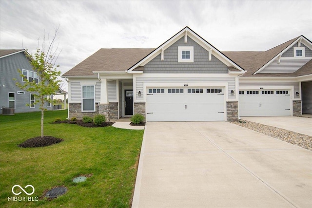 9455 Orchard Cove Dr, Indianapolis, IN 46239 - craftsman house featuring driveway, cooling unit, stone siding, and a front lawn
