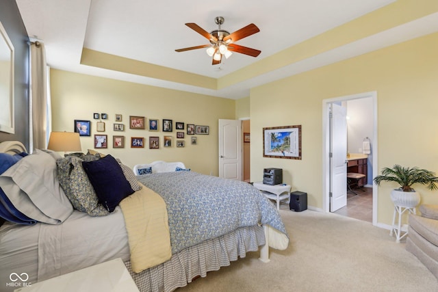 1361 Trescott Dr, Westfield, IN 46074 - carpeted bedroom featuring a raised ceiling, baseboards, ensuite bathroom, and ceiling fan