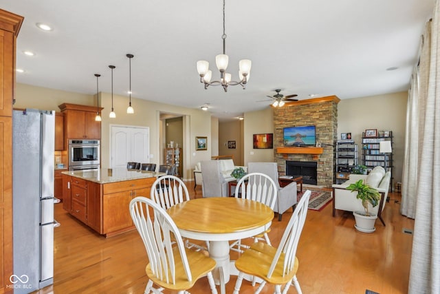1361 Trescott Dr, Westfield, IN 46074 - dining area featuring ceiling fan, light wood-type flooring, a fireplace, recessed lighting, and a chandelier