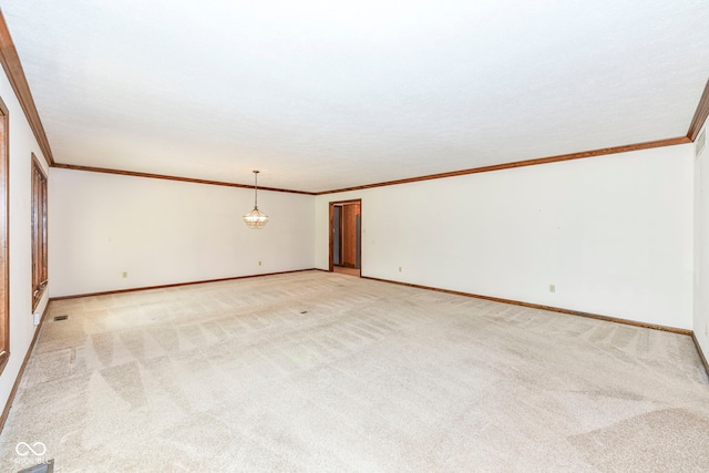 empty room featuring crown molding, visible vents, light colored carpet, and baseboards