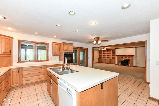 kitchen featuring a sink, ceiling fan, light tile patterned flooring, dishwasher, and a kitchen island with sink