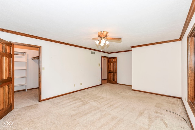 spare room featuring carpet, visible vents, a ceiling fan, and baseboards