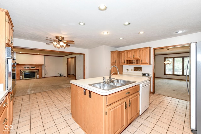 kitchen with light tile patterned floors, a sink, light colored carpet, freestanding refrigerator, and white dishwasher