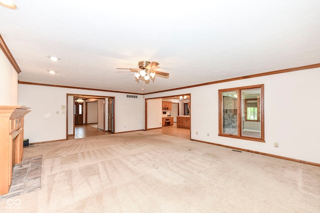 unfurnished living room featuring ceiling fan, crown molding, visible vents, baseboards, and light colored carpet