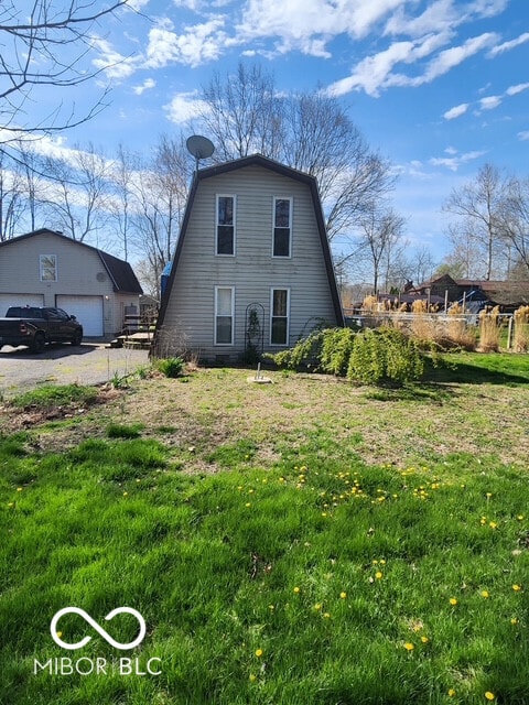 view of home's exterior featuring a detached garage and a gambrel roof