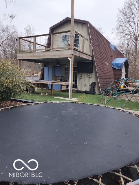 back of house with a gambrel roof and a shingled roof