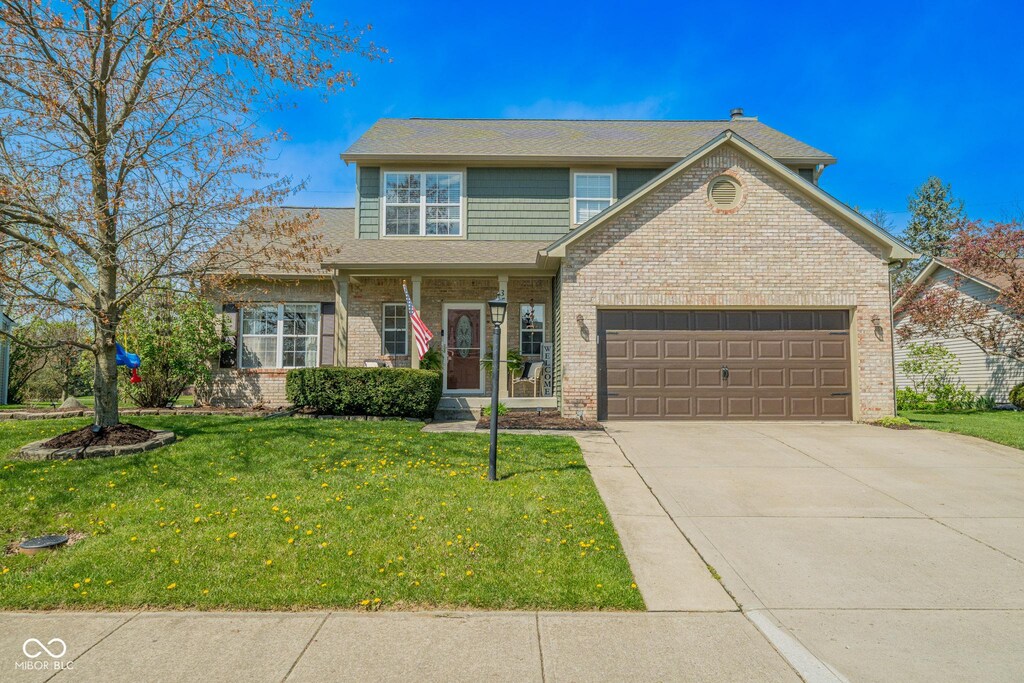 358 W Tansey Xing, Westfield, IN 46074 - traditional-style house with an attached garage, brick siding, a front yard, and concrete driveway
