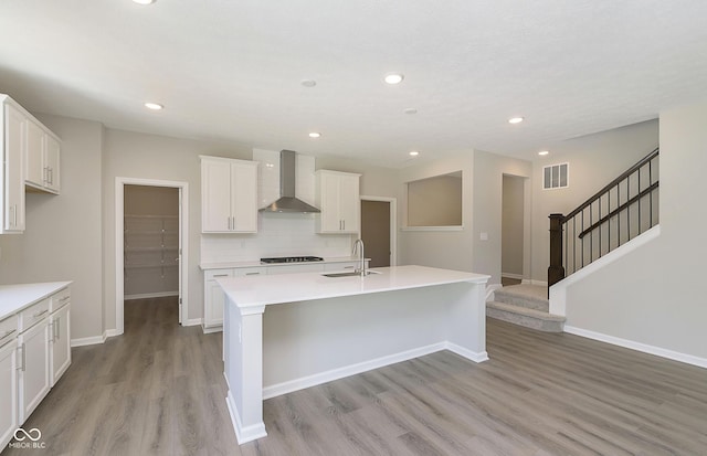 7215 Barrett Dr, Brownsburg, IN 46112 - kitchen with wall chimney exhaust hood, a sink, light wood-type flooring, backsplash, and an island with sink