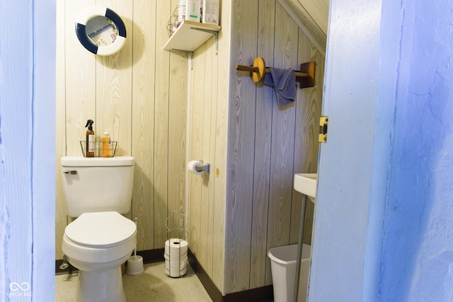 half bathroom with wooden walls and toilet