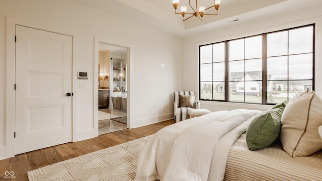 8082 Abington Way, Zionsville, IN 46077 - bedroom with wood finished floors, visible vents, connected bathroom, baseboards, and a chandelier