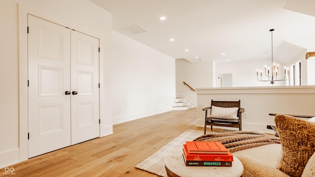 8082 Abington Way, Zionsville, IN 46077 - living area featuring light wood finished floors, baseboards, visible vents, recessed lighting, and a notable chandelier