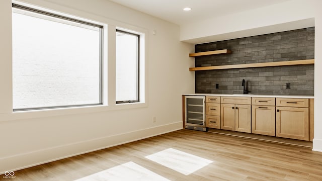 8082 Abington Way, Zionsville, IN 46077 - bar with baseboards, light wood-style floors, backsplash, indoor wet bar, and beverage cooler