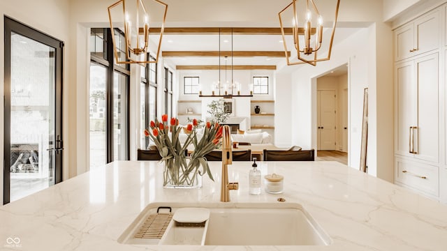 8082 Abington Way, Zionsville, IN 46077 - kitchen with light stone countertops, beam ceiling, pendant lighting, and an inviting chandelier