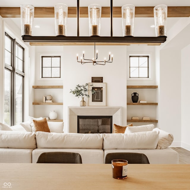 8082 Abington Way, Zionsville, IN 46077 - living room featuring baseboards, a notable chandelier, and built in shelves