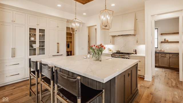 8082 Abington Way, Zionsville, IN 46077 - kitchen with light wood-style flooring, an inviting chandelier, recessed lighting, a kitchen island, and a breakfast bar area