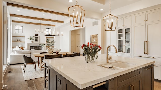 8082 Abington Way, Zionsville, IN 46077 - kitchen featuring dark wood-style flooring, a chandelier, a kitchen island with sink, and a sink
