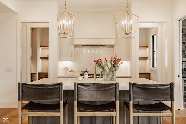8082 Abington Way, Zionsville, IN 46077 - kitchen featuring backsplash, light wood-style floors, a chandelier, and light countertops