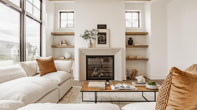 8082 Abington Way, Zionsville, IN 46077 - living room with baseboards, a healthy amount of sunlight, a glass covered fireplace, and wood finished floors