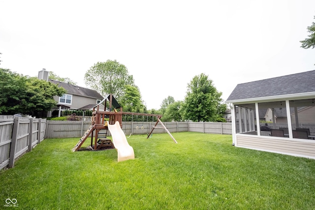 view of yard featuring a playground and a sunroom