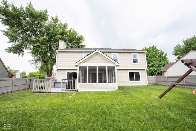 back of house featuring a chimney and a sunroom
