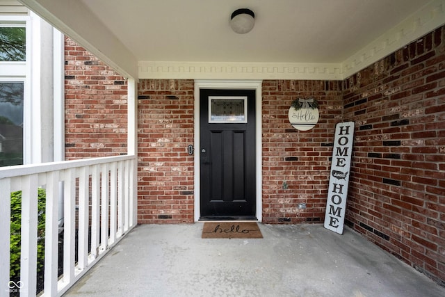 entrance to property with brick siding and covered porch