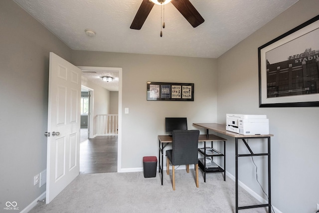 carpeted home office with a ceiling fan and baseboards
