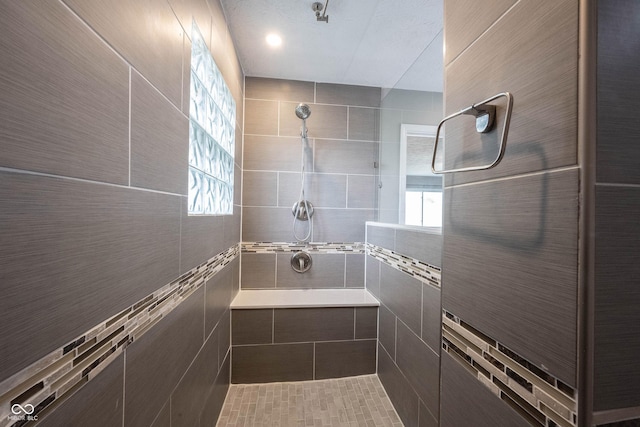 full bathroom featuring tiled shower and healthy amount of natural light
