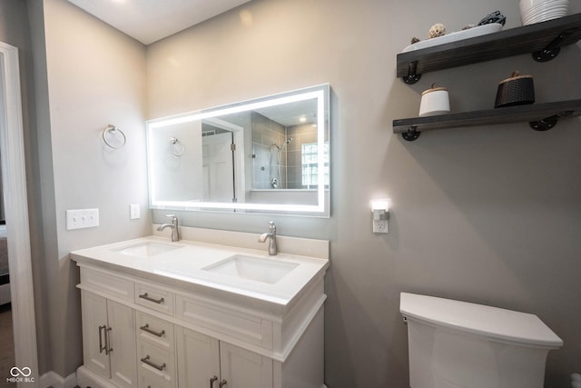bathroom featuring a shower with door, double vanity, and toilet