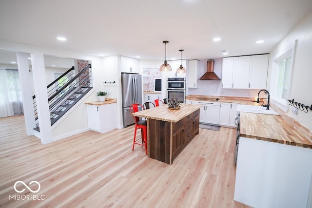 3270 Freedom Rd, Spencer, IN 47460 - kitchen with wooden counters, wall chimney range hood, stainless steel appliances, a sink, and recessed lighting