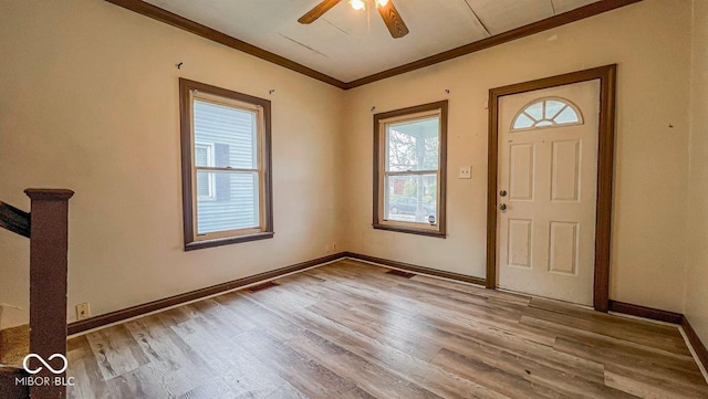 foyer with baseboards, a ceiling fan, wood finished floors, and ornamental molding