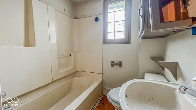 full bathroom featuring washtub / shower combination, a sink, and toilet