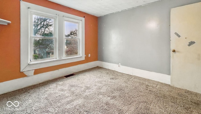 carpeted spare room featuring visible vents