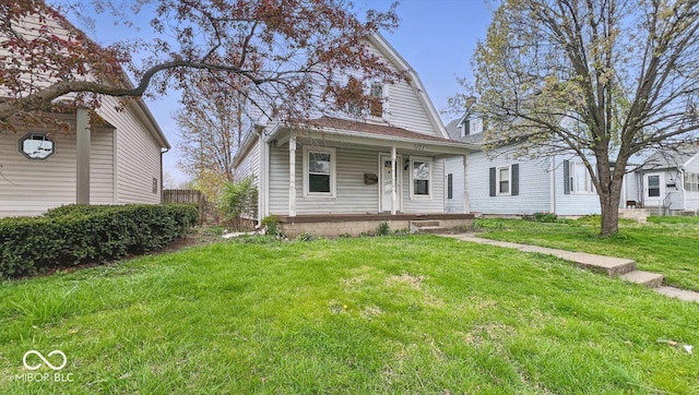 view of front facade featuring a gambrel roof, a front yard, and covered porch