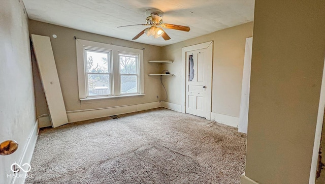 unfurnished bedroom with ceiling fan, carpet floors, a closet, and baseboards