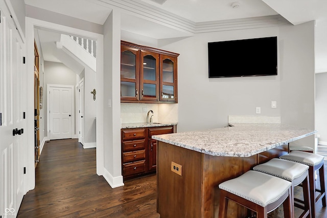 bar with a sink, baseboards, and dark wood-type flooring