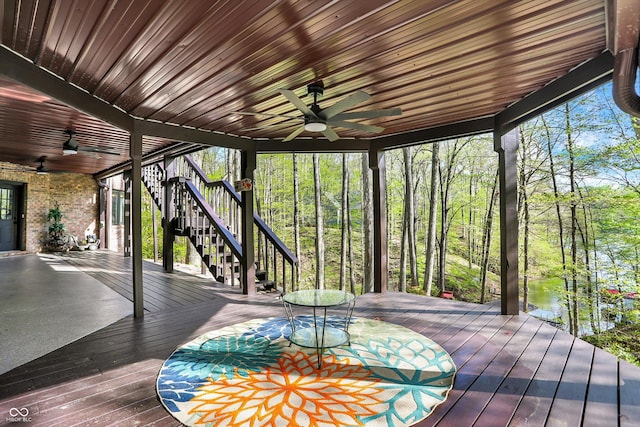 deck featuring ceiling fan and stairway