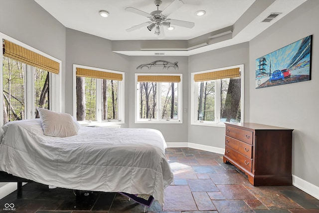 bedroom with ceiling fan, visible vents, baseboards, recessed lighting, and stone tile floors