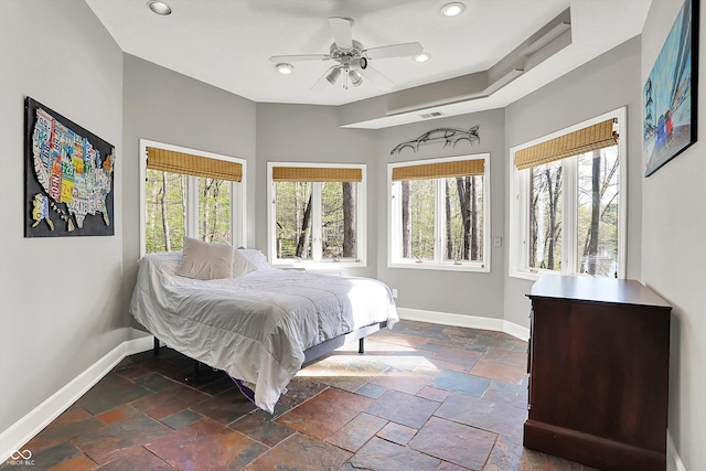 bedroom featuring baseboards, multiple windows, recessed lighting, and stone tile floors
