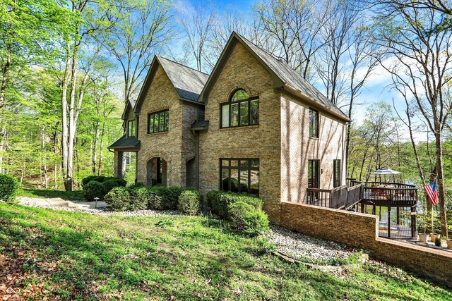 view of front of home featuring brick siding and a deck
