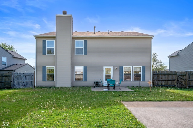 rear view of property with a lawn, a fenced backyard, a patio area, and a chimney