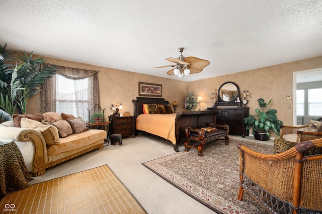 carpeted bedroom with a ceiling fan and a textured ceiling